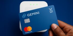 a hand holding a blue card. Gemini's XRP Credit Card Launches: Earn 4% Crypto Back on Everyday Spending