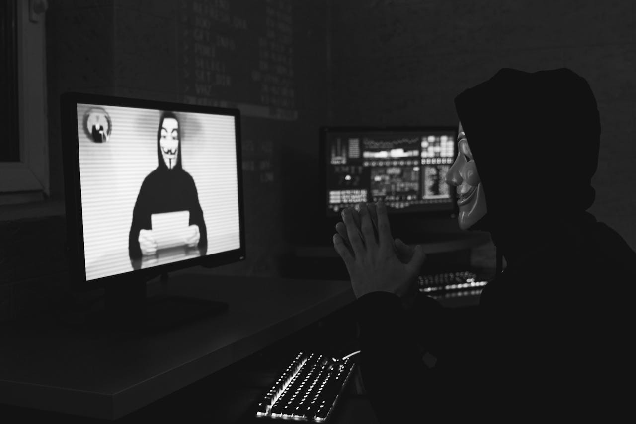 Hacker watching masked figure on screen. Hyperdrive Smart Contract Exploit Drained of $782,000 in Funds
